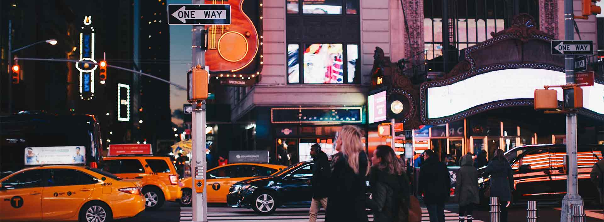 Urban nightlife scene with traffic and pedestrians in New York City.